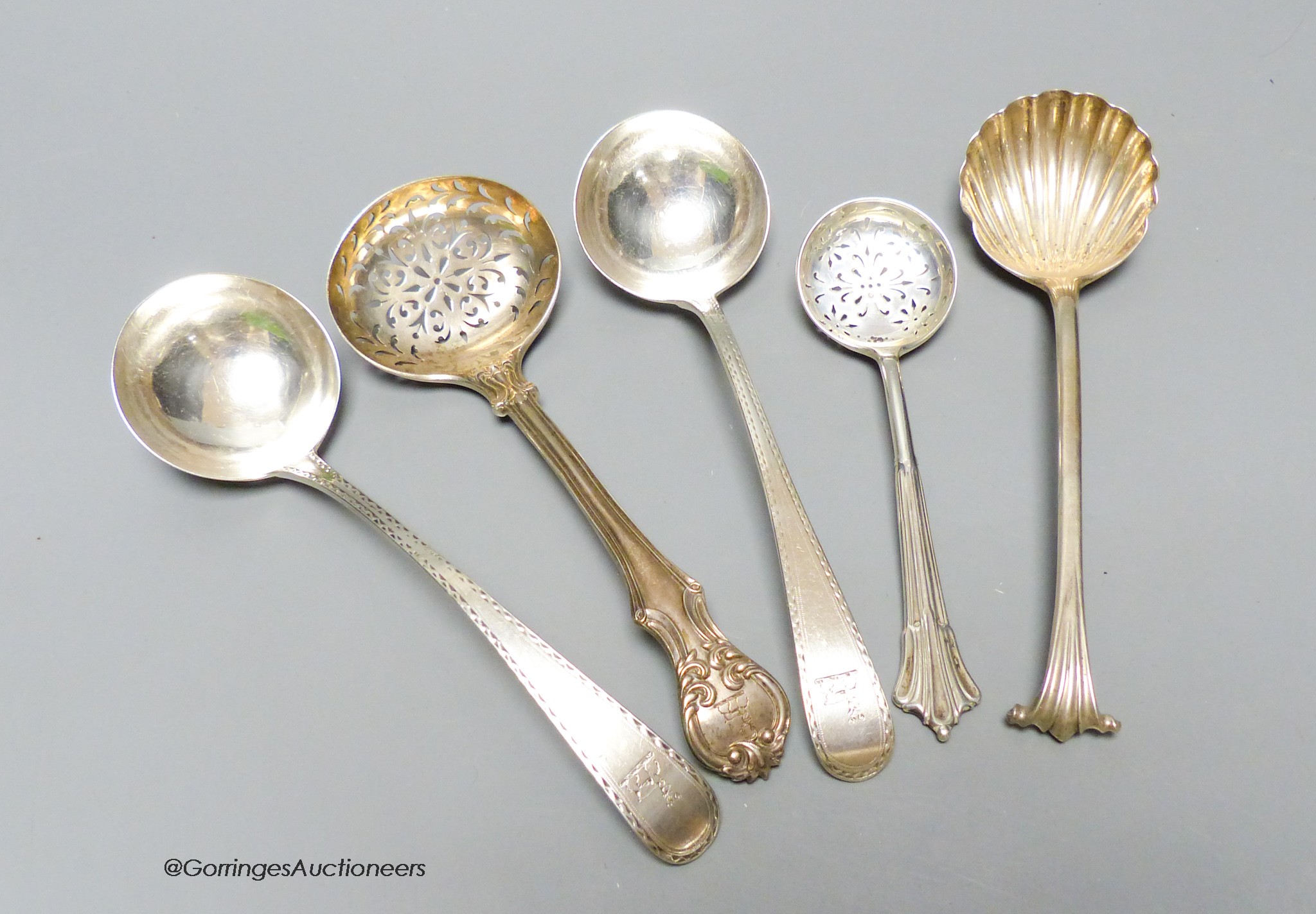 A George III silver onslow pattern shell bowl spoon, London, 1777, two Georgian silver sauce ladles and two later silver sifter spoons